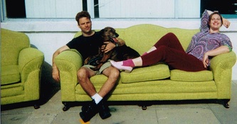 Dan, owner of India Street Antiques, and his assistant Dawn relax on a vintage chartreuse sofa with shop dog Sheba, a Rottweiler and German Shepherd mix. Circa 1994-1995.