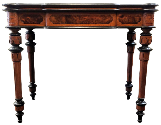 Antique French flip-top games table is constructed of burl figured walnut wood embellished with incised and carved decoration on the frieze, frieze corners, and turned legs at the top. The legs are also lighty fluted with ebonized rings and end in ringed arrow feet.