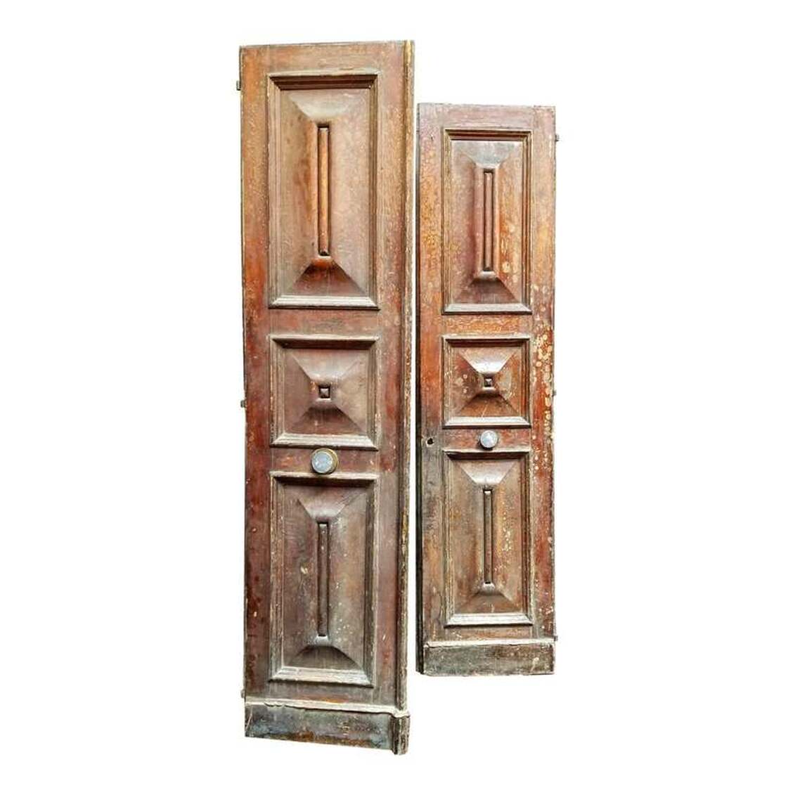 Baron Georges-Eugène Haussmann was appointed by Napoleon III to conduct an urban renewal of Medieval Paris beginning in 1853. The work carried through 1927. This pair of French oak panel doors date from the late-19th century. One side shows the original red paint and zinc door pulls. The second side shows the original cream paint.