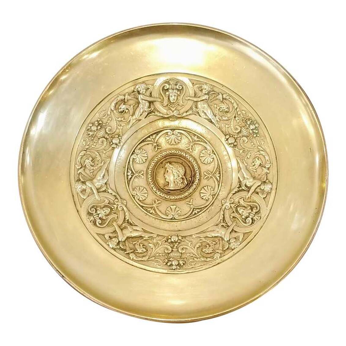 Antique doré bronze footed tazza in the Greek Revival style popular from the 1830s throughout the 1860s and executed in the manner of French bronze maker and caster Ferdinand Barbedienne. The tazza is decorated with symbols of the Greek Goddess Athena. A profile of Athena is at center framed with a guilloche border and an outer anthemion border. The outer ring features three heads of Medusa upon aegises with pairs of cherubs. Classical motifs abound with acanthus leaf arabesques bursting from flaming torches and ending in dragon heads, urns overflowing with fruit, and the previously mentioned design elements. The makers mark on the bottom of the foot indicates tazza is from Tiffany and Company, is pattern number 0101, order number 5958, and was crafted under the direction of Edward C. Moore as indicated by the style of the