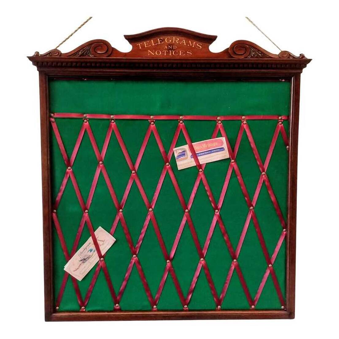 Telegrams and Notices board from late-Victorian England.Neoclassical style mahogany wood frame surrounds a center of new felt and ribbon. Under the bonnet top with scrolls and acanthus leaves is lettering spelling