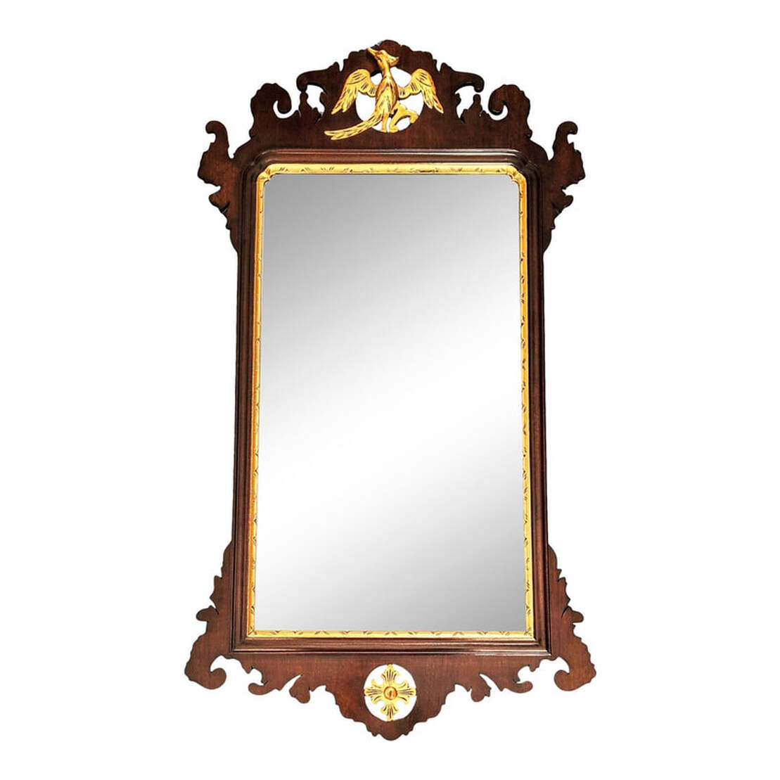Vintage Wallace Nutting mirror surrounded by mahogany wood sawed open fretwork and decorated with carved gilt decorations.  Rectangular beveled looking glass in a parcel gilt carved mahogany frame.  At top is a carved and gilded bird, a crane with a crest feather resting on a branch.  At bottom is a carved and gilded foliated quatrefoil.  The back is covered with a fruit wood panel and is marked multiple times with the Wallace Nutting block letter iron brand signature which was in use from 1925 through the 1930s.