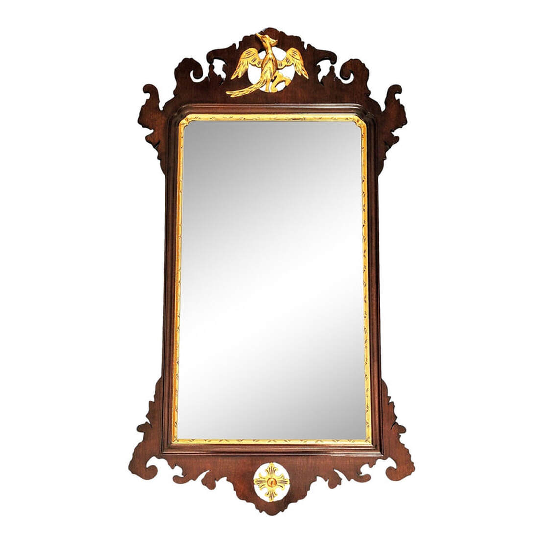 Vintage Wallace Nutting mirror surrounded by mahogany wood sawed open fretwork and decorated with carved gilt decorations. Rectangular beveled looking glass in a parcel gilt carved mahogany frame. At top is a carved and gilded bird, a crane with a crest feather resting on a branch. At bottom is a carved and gilded foliated quatrefoil. The back is covered with a fruit wood panel and is marked multiple times with the Wallace Nutting block letter iron brand signature which was in use from 1925 through the 1930s.