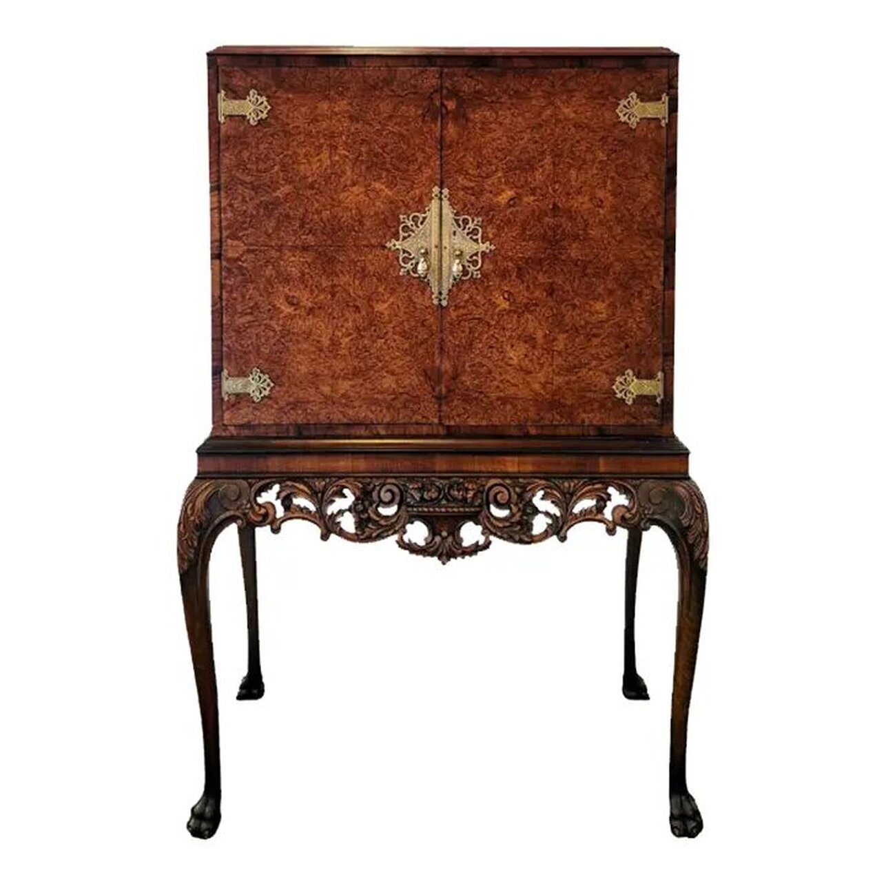 Early 20th century Queen Anne style cocktail cabinet on stand by Hille of London. The cabinet is constructed of burl English walnut with burr walnut veneer on the two front doors. The top is flat, allowing for use as a storage shelf. The doors are embellished with etched brass strap hinges, escutcheons, and teardrop pulls. The interior of the drinks cabinet is lined with sycamore wood, features a mirrored back and base, two glass shelves, and a mirrored slide-out prep station. The mirror on the bottom may be removed for cleaning the wood base when needed. The two glass shelves are removable. The stand's apron is embellished with neoclassic style carvings of scrolls, swags, acanthus leaves, and a basket of flowers at the center. The cabriole legs are embellished with carvings of acanthus leaves on the knees. The legs end in hairy paw and claw feet. The carvings are well-done and finely detailed. The drinks cabinet will complement interiors featuring elements of Georgian, Queen Anne, Chippendale, Chinoiserie, and Baroque. Cocktail cabinet is in stock now at India Street Antiques in San Diego and is ready for pick-up, delivery, and shipping.